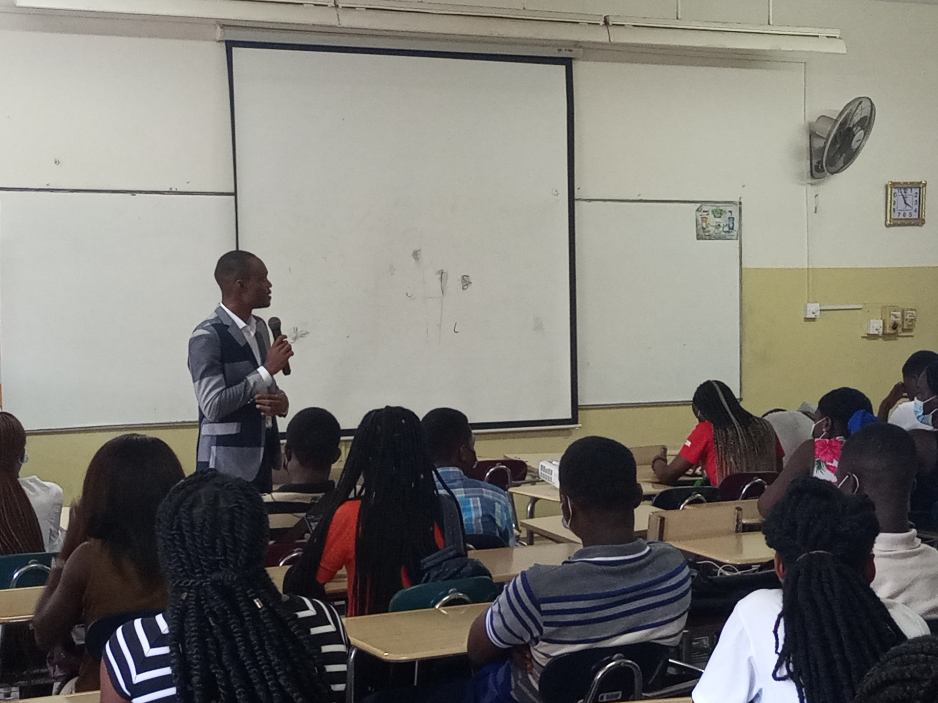 Finex facilitator with a microphone teaching a classroom of attentive students